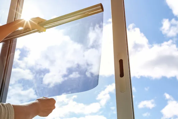 Close-up of window tint being applied to glass sliding door.